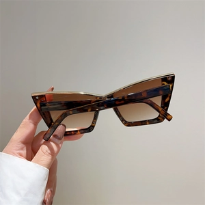 Detail of tortoise shell cat-eye sunglasses with gold metal trim and gradient lenses