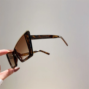 Detail of tortoise shell frames and gold metal accents on cat eye sunglasses