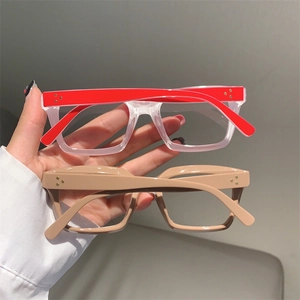 Detail of square frame glasses showing gold rivet accents and two-tone color temple design