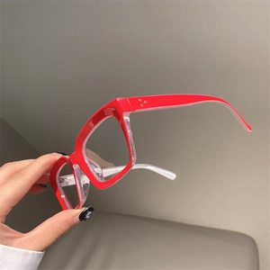 Detail of red and white oversized glasses frame with triple gold rivet decorations