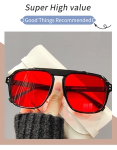 Détail de lunettes de soleil carrées avec monture noire brillante et verres rouges
