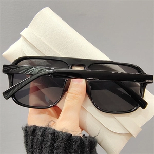 Grosse lunettes de soleil carrées noires avec un étui en cuir crème texturé