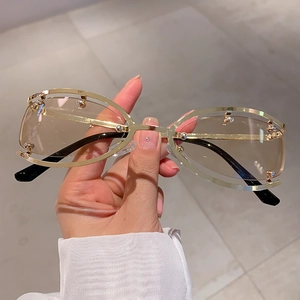 Détail de lunettes de soleil ovales sans monture avec cadre doré et perles