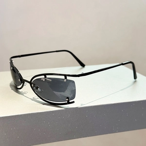 Détail de lunettes de soleil en métal noir à monture ajourée, rivets et verres gris