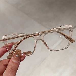 Close-up of champagne resin frames with faceted texture and slim gold metal temples
