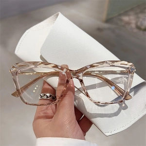 Detail of champagne resin glasses with geometric diamond cut edges and gold metal temples