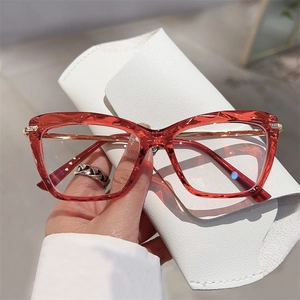 Detail of red geometric faceted frames with slim gold metal temples and leather pouch