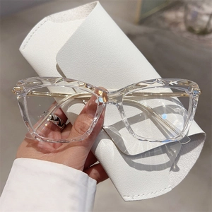 Detail of transparent polygonal facet glasses with gold metal temples and white case