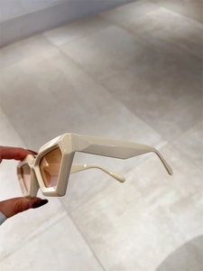 Vue détaillée des lunettes de soleil œil-de-chat crème à monture géométrique