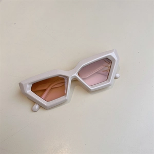 Détail de lunettes de soleil hexagonales géométriques avec monture crème et verres pêche
