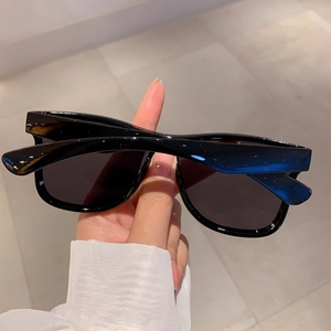 Detail of glossy black oversized rimless sunglasses with dark anti-glare lenses