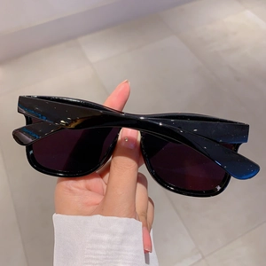 Modern black rimless oversized sunglasses with glossy finish and dark lenses