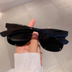 Close-up of sleek black oversized rimless sunglasses with shiny finish and uniform texture