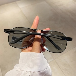 Detail of classic black metal aviator sunglasses held to show high-quality matte frame finish