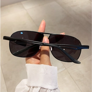 Detail of black metal aviator sunglasses with polarized lenses and double bridge design