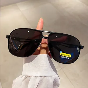 Close-up of polarized aviator sunglasses with yellow driving lens sticker and black frame