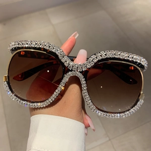 Close-up of tortoise shell oversized sunglasses featuring luxury rhinestone embellishments