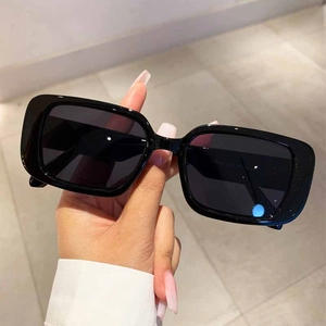 Classic black rectangular chunky frame sunglasses with dark lenses in a handheld view