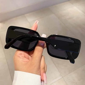 Detail view of retro rectangle black sunglasses with glossy frames and dark lenses