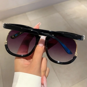 Oversized black fashion sunglasses with gradient lenses and gold rhinestone accents