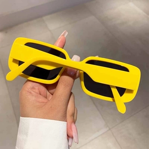 Close-up of stylish rectangular sunglasses with bright yellow frames and dark lenses