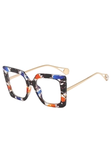 Detail of square glasses featuring colorful tortoiseshell frames and gold metal temples