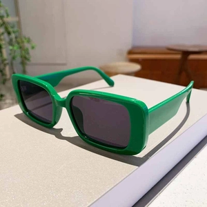 Detail view of bright green square frame sunglasses with dark grey polarized lenses