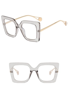 Detail of square glasses with smoke grey frames and asymmetric gold metal temples