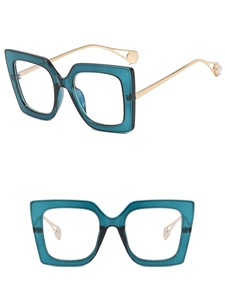 Detail of square teal frames with gold metal temples and elegant pearl accents