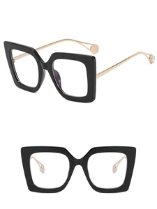 Detail of square black frames with gold metal temples and unique pearl accents