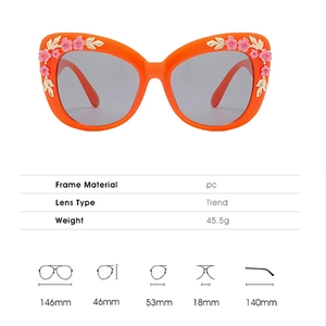 Macro detail of orange cat eye sunglasses with pink floral and gold leaf decorations