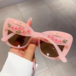 Detailed view of pink floral sunglasses with 3D flower accents and crystal rhinestones