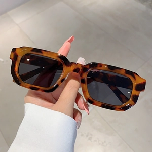 Gros plan de lunettes de soleil vintage carrées en écailles de tortue et verres gris