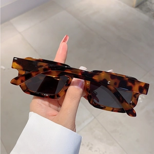 Gros plan de lunettes de soleil carrées léopard avec verres foncés à la main