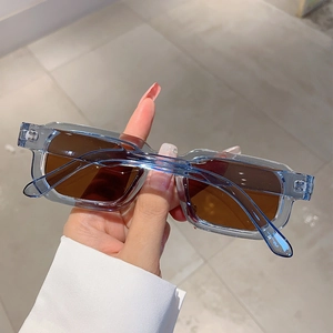 Détail de lunettes de soleil rectangulaires avec monture bleue et verres marron
