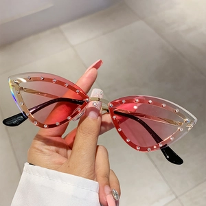 Close-up of pink gradient cat-eye sunglasses with rhinestone edges and gold frame