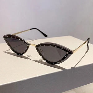 Detail of rimless cat-eye sunglasses with rhinestone edges and golden metal temples
