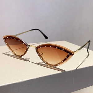 Macro detail of cat-eye sunglasses with gradient lenses and rhinestone-studded rim