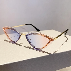 Detail of gradient cat-eye sunglasses with rhinestone trim and slim gold metal temples