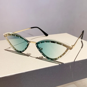 Detail of cat-eye sunglasses with rhinestone edges and gold frame on a display stand