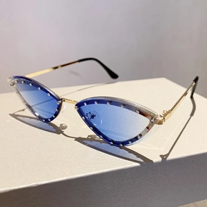 Macro detail of cat-eye sunglasses with blue gradient lenses and rhinestone-encrusted edges