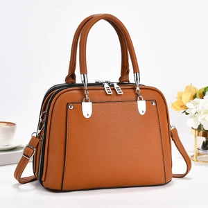 Macro detail of brown pebbled leather texture and silver buckle on tote bag