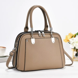 Detail of khaki leather tote with multi-compartment zip design and silver hardware