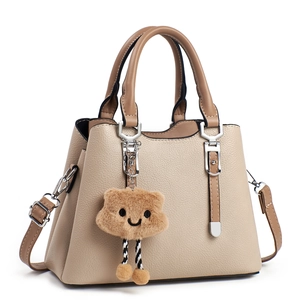 Elegant beige and khaki leather handbag with top handles and a cute fuzzy cloud charm
