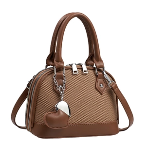 Sac coque marron tissé chic pour femmes avec finitions en cuir et breloque cœur sur blanc