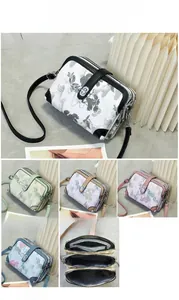 Detail view of printed floral crossbody bag with three zipper compartments and size info