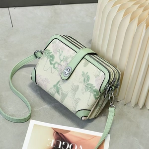 Floral print crossbody bag in light green with three zipper compartments and shoulder strap