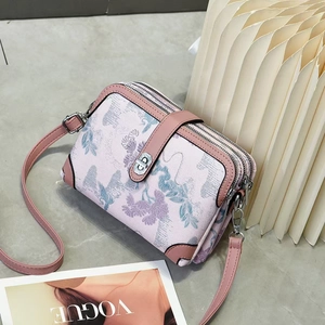 Floral print crossbody bag with three zippers and pink leather strap in 45-degree view