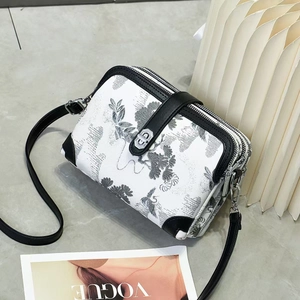 Detail of multi-layer silver zippers on white ink floral print crossbody bag
