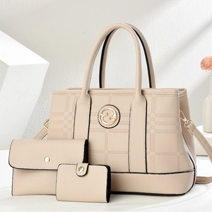 Beige embossed three-piece handbag set featuring tote and matching wallets on white stands